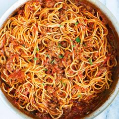 spaghetti with meat sauce and parsley in a pan