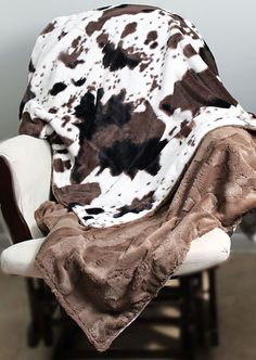 a cow print blanket sitting on top of a chair