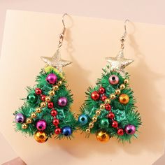 a pair of christmas tree earrings with ornaments