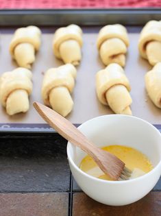 doughnuts are being made and ready to be baked on the baking sheet with a wooden spoon