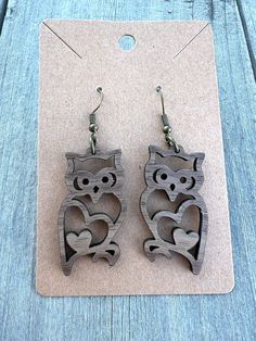 wooden owl earrings with heart cutouts on them