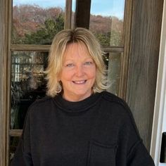 a woman standing in front of a door with her hands on her hips and looking at the camera