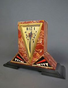 an art deco clock with red marble and gold trimmings, on a black stand