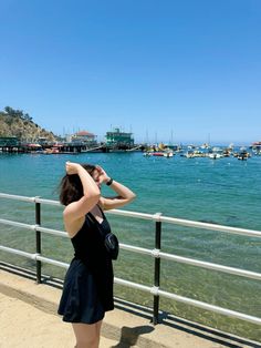 a woman looking out over the water at boats