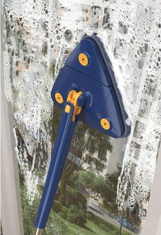 a blue and yellow umbrella is hanging on the side of a window with water droplets