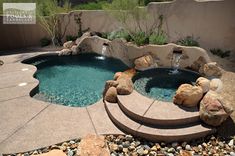 an outdoor pool with rocks and water features