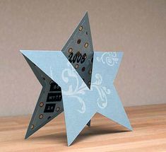 an origami star with the word love on it sitting on top of a wooden table