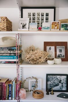 books and pictures are on the shelves in this room