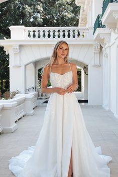 a woman in a white wedding dress posing for the camera