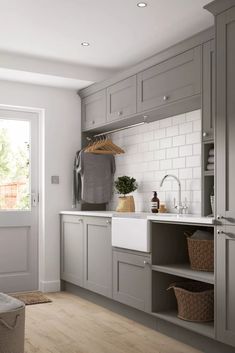 a kitchen with gray cabinets and wooden floors