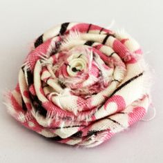 a close up of a flower on a white surface with pink and black plaid fabric