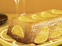 a yellow plate topped with a cake covered in lemon slices