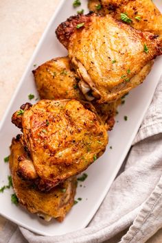 three pieces of chicken sitting on top of a white plate