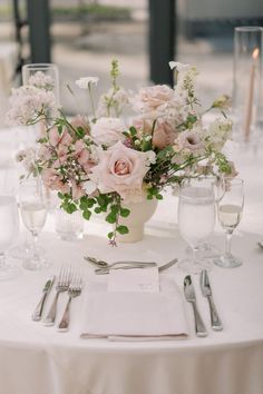 the table is set with silverware and flowers