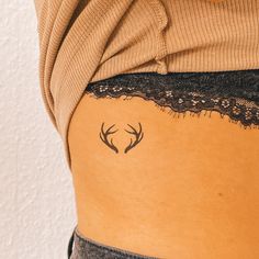 the back of a woman's stomach with two deer antlers on her side