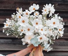 a person holding a bouquet of white flowers