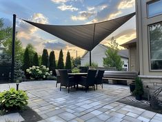 an outdoor dining area with patio furniture and shade sail