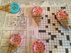 three ice cream cones with sprinkles are on a table next to a blue button