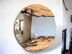 a circular mirror hanging on the side of a wall