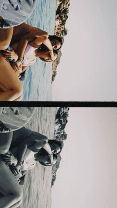 two women standing next to each other in front of the ocean and one woman holding a surfboard