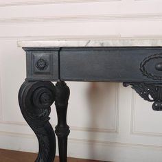 an antique black desk with marble top