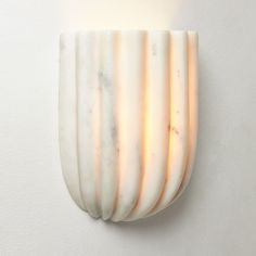 a white wall mounted light that is on the side of a wall