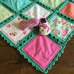 a pair of baby booties sitting on top of a quilted placemat with flowers