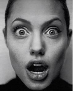 a black and white photo of a woman's face with her mouth open in front of the camera