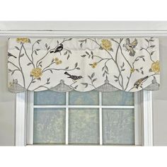 a window curtain with birds on it and flowers in the bottom, behind which is a white valance