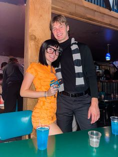 a man and woman standing next to each other at a table