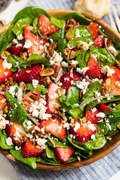 a salad with spinach, strawberries and feta cheese