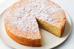 a white plate topped with a cake covered in powdered sugar