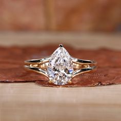 a close up of a diamond ring on a wooden surface