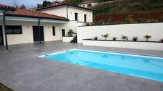 an empty swimming pool in front of a house