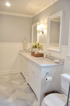 a bathroom with a toilet, sink and mirror in it's center piece is shown