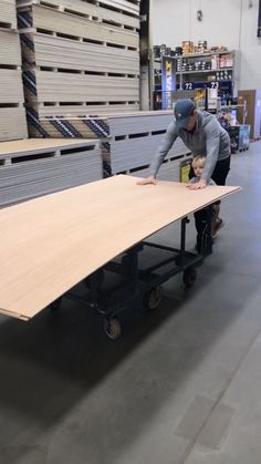 two men working on a table in a warehouse