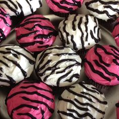 there are many cupcakes with pink and black frosting on them in the tray