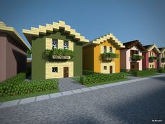 a row of colorful houses sitting next to each other on a brick road in front of grass and bushes