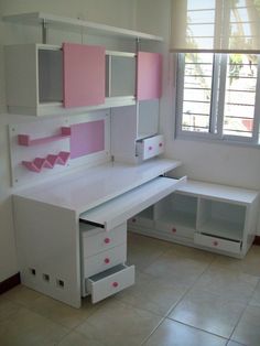 a white desk with pink and grey drawers in a room that has tile flooring