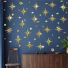 a blue wall with gold stars on it and a wooden chair in front of it