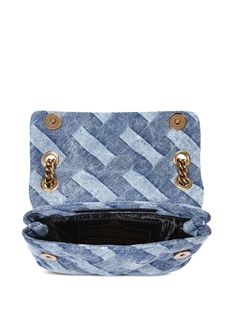 Find KURT GEIGER Mini Kensington Denim Shoulder Bag on Editorialist. The Kurt Geiger London Kensington Denim Shoulder Bag features a signature eagle head charm, gold-tone hardware, and a sliding chain-link shoulder strap. This mini bag is crafted from acid wash denim with an interwoven design print and has a foldover top with a magnetic fastening. It includes a main compartment and an internal slip pocket. The bag can be worn on the shoulder or crossbody.