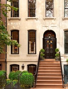 an apartment building with stairs leading up to the front door