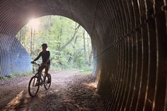 a person riding a bike through a tunnel