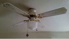 a white ceiling fan with gold trim and chandelier hanging from it's blades