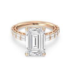 an emerald cut engagement ring with baguets on the shoulders and side stones in rose gold