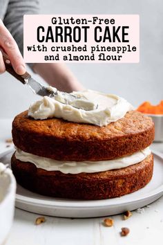 a person spreading icing on top of a carrot cake with cream cheese frosting