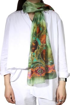 This silk scarf is designed and handmade in Armenia, by sisters Anna and Azatuhi Stepanyan. The scarf is hand painted in the technique of cold batik. The motifs include pomegranates, considered a symbol of fertility and good fortune in Armenia, as well as a guard against the Evil Eye. The multicolored scarf is framed with traditional Armenian motifs. Traditional Green Scarf As Gift, Traditional Green Scarves As Gift, Bohemian Handmade Silk Scarves, Handmade Silk Bohemian Scarf, Handmade Silk Bohemian Scarves, Bohemian Batik Print Silk Scarf, Bohemian Silk Scarf With Batik Print, Traditional Handmade Silk Scarves, Handmade Traditional Silk Scarf