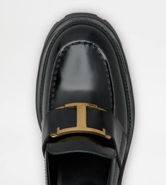 Loafers in elegant semi-shiny leather with a band and branded metal T Timeless accessory, rubber pebble detailing on the heel and rubber lugged outsole. Black Calf Leather Loafers With Metal Feet, Classic Leather Shoes With Metal Feet, Formal Patent Leather Loafers With Lug Sole, Luxury Leather Shoes With Metal Feet For Formal Occasions, Classic Loafers With Lug Sole In Calf Leather, Classic Calf Leather Loafers With Lug Sole, Luxury Black Loafers With Leather Footbed, Luxury Office Loafers With Rubber Sole, Business Loafers With Metal Feet And Leather