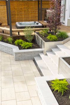 a hot tub sitting next to a wooden deck in the middle of a yard with steps leading up to it