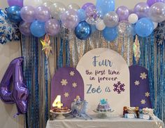 a table topped with balloons and cake next to a sign that says four the first time in forever